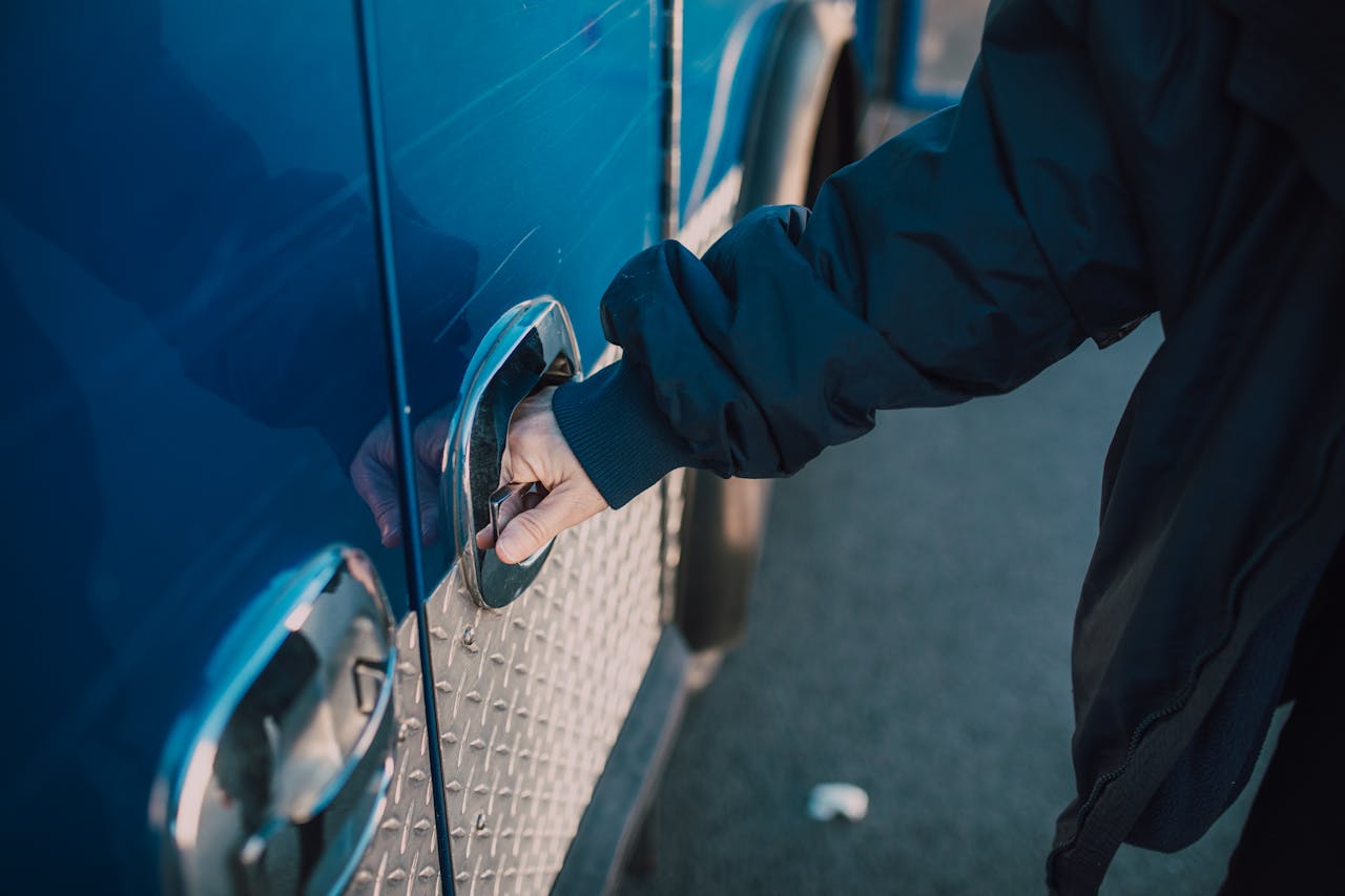 Crafting Captivating Headlines: Your awesome post title goes here A person in a jacket opens a handle on a blue emergency vehicle, likely an ambulance.