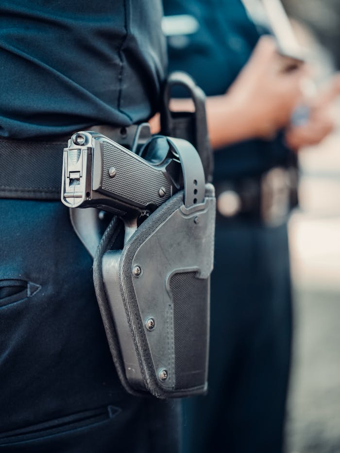 The Art of Drawing Readers In: Your attractive post title goes here Detailed view of a police officer's gun holstered on the belt with blurred background.
